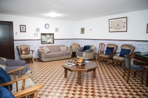 a living room with couches and chairs and a table at Alojamento Local Familiar in Monfortinho