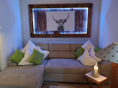 una sala de estar con un sofá con una foto de un toro en Ferienwohnung Hörndlwand Ruhpolding en Ruhpolding
