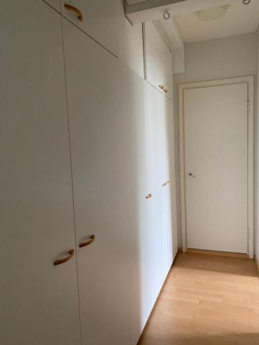 ein leeres Zimmer mit weißen Schränken und einer Tür in der Unterkunft Apartments ”Enkeli” in Kotka