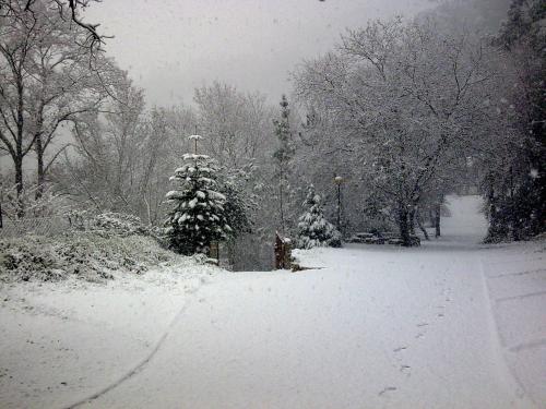 a snow covered park with a christmas tree and a cross at Casa do Palheiro de Cima in Geres
