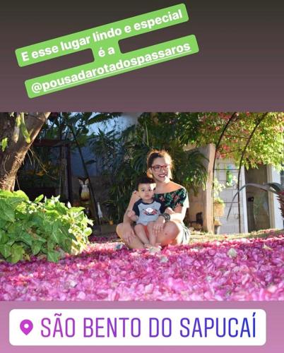 a woman and a baby sitting in a field of flowers at Pousada Rota dos Pássaros in São Bento do Sapucaí