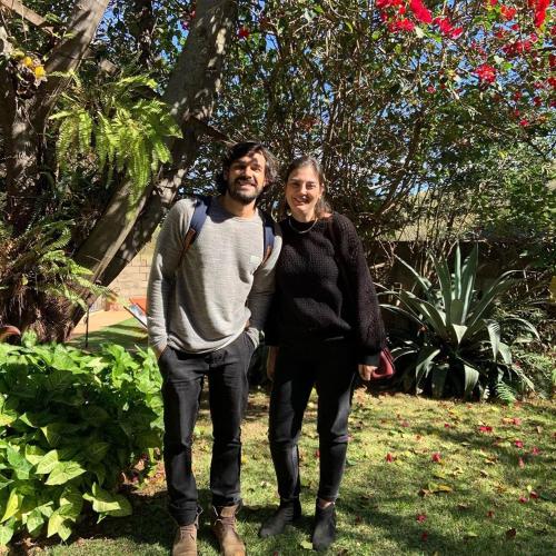 a man and a woman standing in a garden at Pousada Rota dos Pássaros in São Bento do Sapucaí
