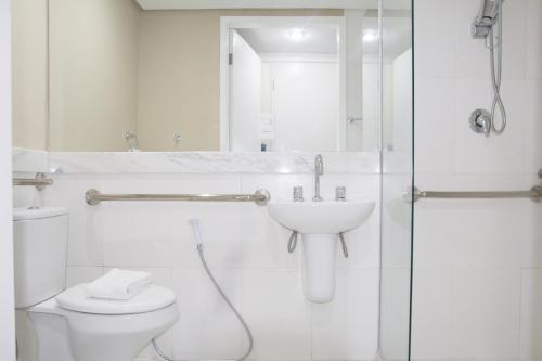 a bathroom with a toilet and a sink and a shower at Bahiamar Hotel in Salvador