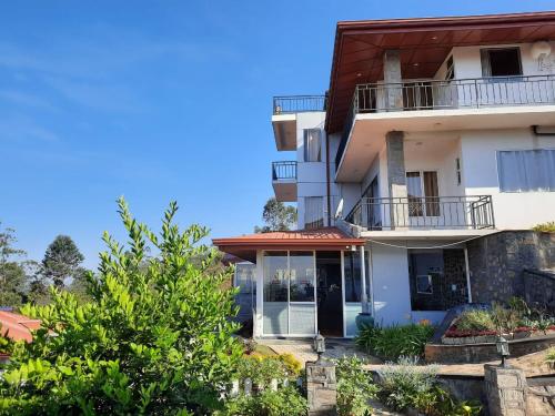 a large white house with a balcony at Daynish Rock Bungalow in Hatton