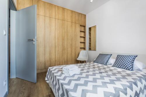 - une chambre avec un lit et un mur en bois dans l'établissement ResiNest Apartamenty Butikowa Kamienica M40, à Białystok