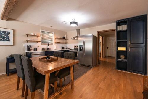 a kitchen with a wooden table and a stainless steel refrigerator at Escape to a Restored 1920s East Waco Bungalow in Waco