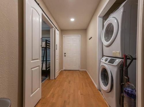 a hallway with a washer and dryer in a house at Escape to a Restored 1920s East Waco Bungalow in Waco