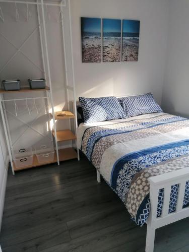 a small bedroom with a bed and a shelf at Chalet at Penstowe Holiday Park Near Bude in Bude