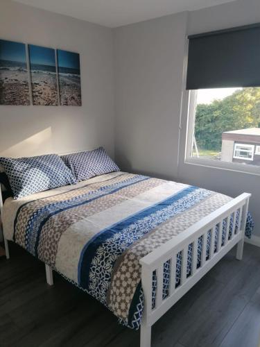a bed in a bedroom with a window and a bedspread at Chalet at Penstowe Holiday Park Near Bude in Bude