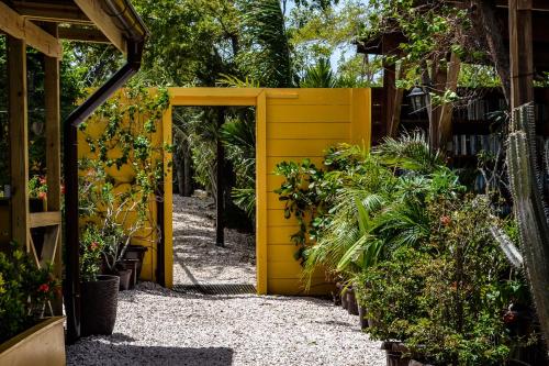 a yellow door in a garden with plants at Jan Kok Lodges in Willibrordus