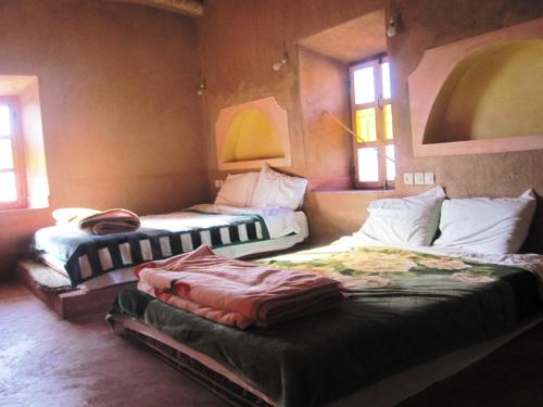 a room with two beds in a room at Casbah d'hôte La Jeanne Tourisme Ecologique in Boumalne