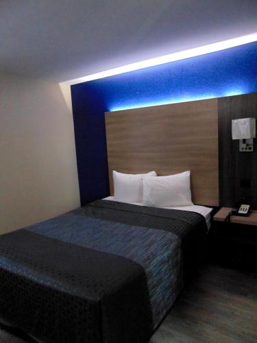 a hotel room with a bed with a blue accent at Somatel Nashville Airport in Nashville