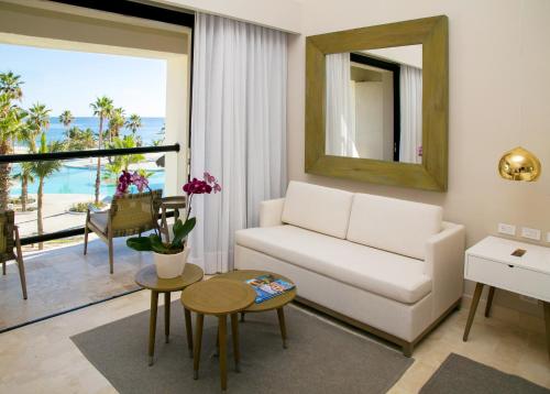 a living room with a couch a table and chairs at Paradisus Los Cabos All Inclusive in Cabo San Lucas