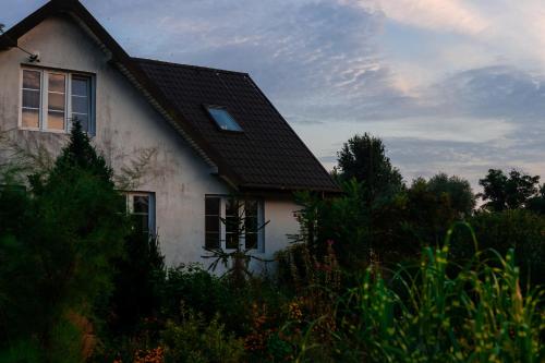a white house with a black roof at bizon in Sadowne