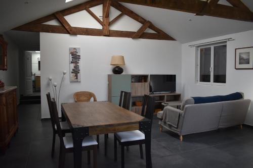 een woonkamer met een eettafel en een bank bij Albizia rouge - Gîte de charme à la campagne in Galgon