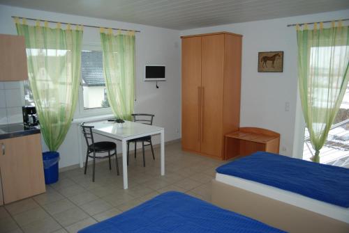 1 dormitorio con cama, escritorio y mesa en Ferienwohnungen Schäfer, en Obersulm