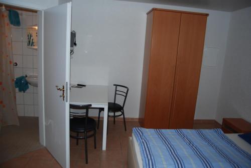 a bedroom with a table and chairs and a bed at Ferienwohnungen Schäfer in Obersulm