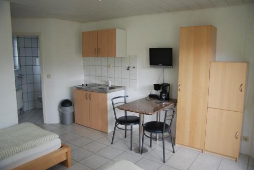 a small kitchen with a table and chairs in a room at Ferienwohnungen Schäfer in Obersulm