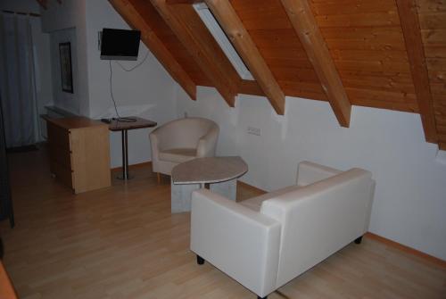 a living room with white furniture and a wooden ceiling at Ferienwohnungen Schäfer in Obersulm
