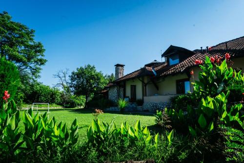 a house with a yard with green grass at ATOS Srebrno jezero - Villa and Restaurant in Veliko Gradište