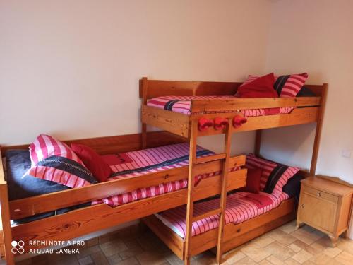 2 letti a castello in una camera con cuscini rossi di Cal Mosqueta a Sant Llorenç de Morunys