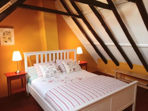 ein Schlafzimmer mit einem weißen Bett mit zwei Tischen und zwei Lampen in der Unterkunft Winsum - Groningen - 6 pers. Cosy Cottage - Op en Bie t Woater in Winsum