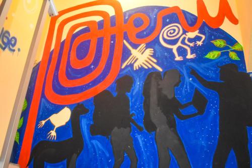 a mural of people and a dog on a wall at Passion Hostel - Barranco in Lima