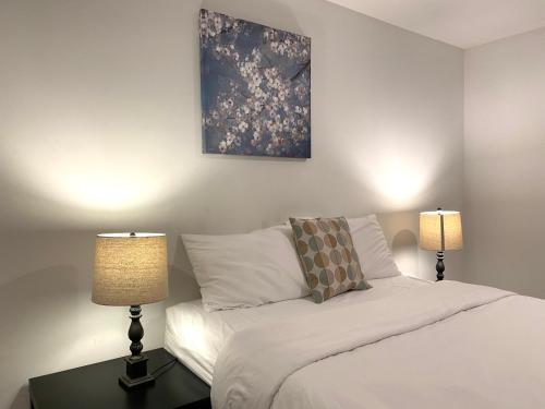 a bedroom with a bed with two lamps and a painting at Alina & Fanny - Philadelphia Convention Center in Philadelphia