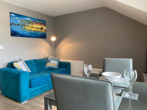 salon z niebieską kanapą i stołem w obiekcie VIP Church Loft Apartment w mieście Portadown
