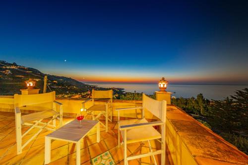 a balcony with chairs and a table and a lighthouse at Residence Agape in Cefalù