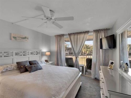 - une chambre avec un grand lit et un ventilateur de plafond dans l'établissement Magnolia House at Destin Pointe I, à Destin