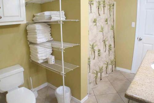 a bathroom with a toilet and towels on shelves at Gulfview Condominiums in Destin