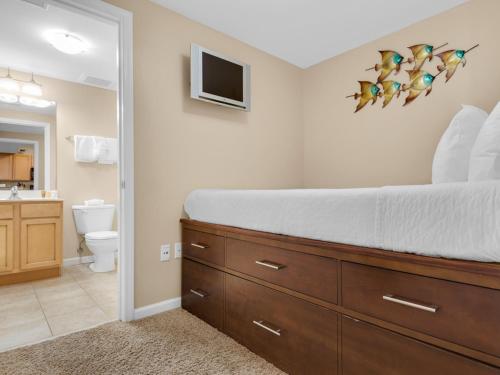 a bedroom with a large bed and a bathroom at The Palms of Destin in Destin