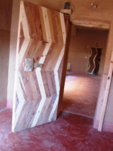 a wooden door in the middle of a room at Casbah d'hôte La Jeanne Tourisme Ecologique in Boumalne