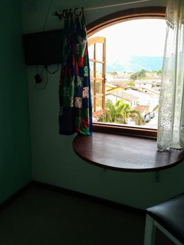 a window in a room with a table and a view at SunriseBelaVista Pousada e Flats in Paraty