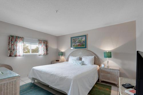 1 dormitorio con 1 cama blanca y 2 ventanas en Crystal Sands II, en Destin