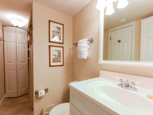 La salle de bains est pourvue d'un lavabo, de toilettes et d'un miroir. dans l'établissement Mainsail II, à Destin