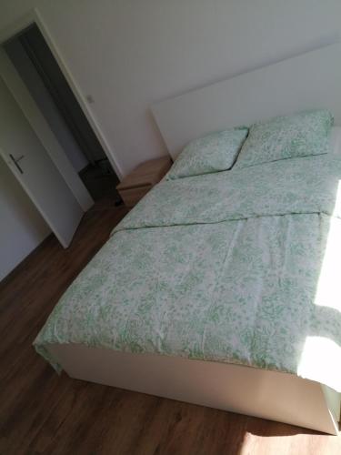 a bedroom with a bed with a green comforter at Appartement cosy arrêt de tram Saint-Louis Grenze in Saint-Louis