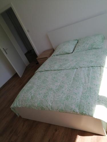 une chambre avec un lit avec une couette verte dans l'établissement Appartement cosy arrêt de tram Saint-Louis Grenze, à Saint-Louis