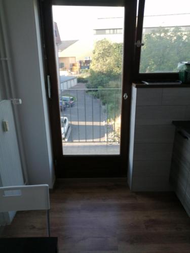 a door to a balcony with a view of a street at Appartement cosy arrêt de tram Saint-Louis Grenze in Saint-Louis