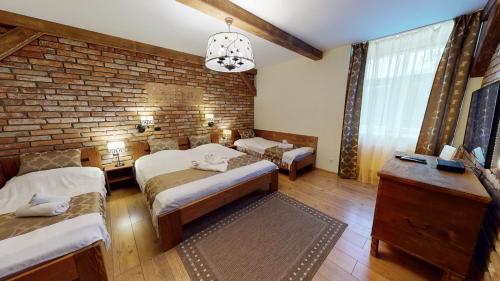 a bedroom with two beds and a brick wall at Apartmán Marta, 200 m Ski Tatranska Lomnica in Vysoke Tatry - Tatranska Lomnica.