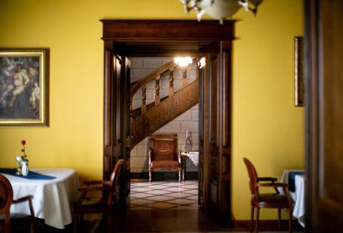 a dining room with a staircase and a table and chairs at Zamek Dubiecko in Dubiecko