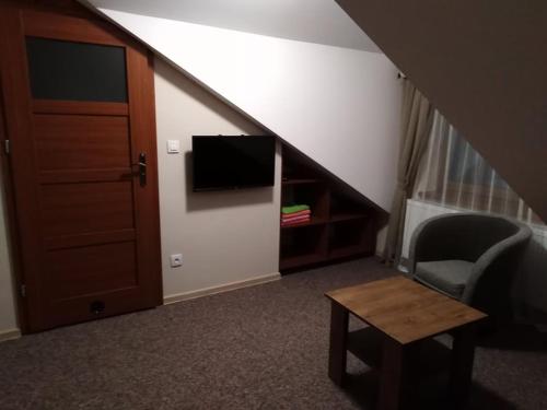 a room with a staircase with a tv and a chair at Ośrodek Wczasowy "Wczasy pod gruszą" in Biecz
