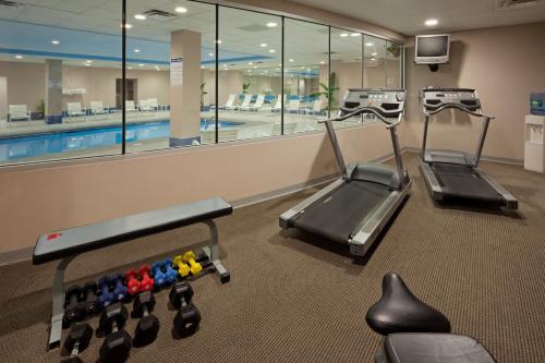 a gym with three exercise bikes and a swimming pool at Holiday Inn Salem by IHG in Salem