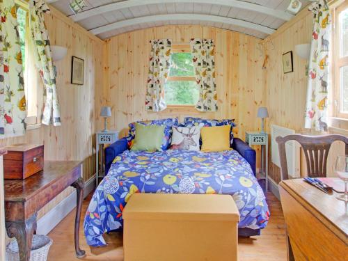 a bedroom with a bed in a room with wooden walls at Hill view Holiday Home with Garden in Taunton