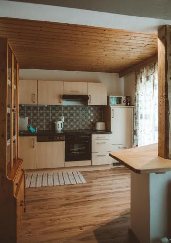 a kitchen with wooden cabinets and a wooden floor at Stockachhof in Fügenberg