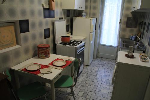 Milano: accogliente appartamento in zona comoda في ميلانو: مطبخ مع طاولة عليها لوحات