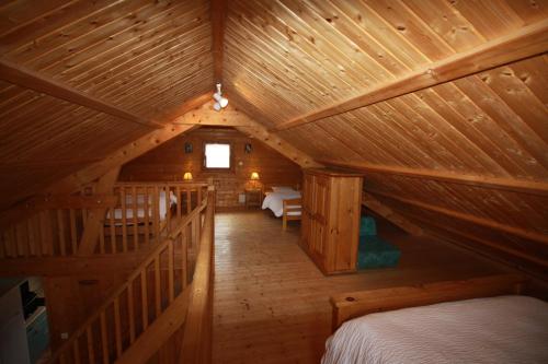 RochessonにあるGite Roche Des Ducs avec Piscine toute l'année, Spa, Sauna, Hammamのログキャビン内のベッドルームを望めます。