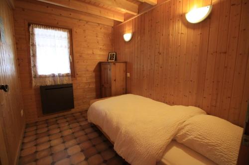 a bedroom with a bed in a wooden room at Gite Roche Des Ducs avec Piscine toute l'année, Spa, Sauna, Hammam in Rochesson