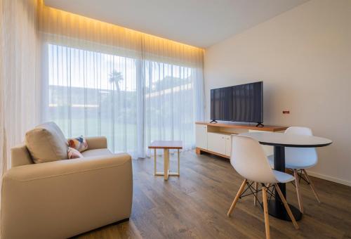 a living room with a couch and a table and a television at Casas Amarelas Azores in Ponta Delgada